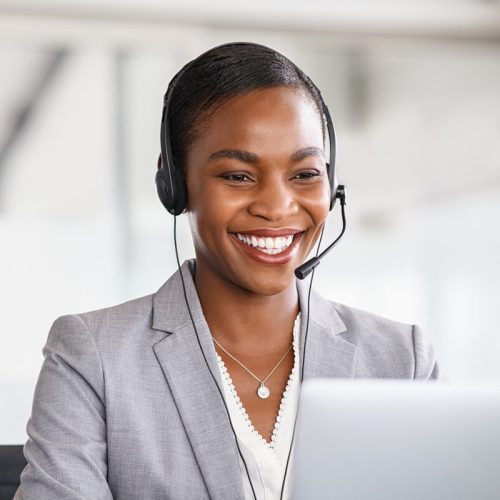 Customer service woman working on a phone call Smiling african american customer care representative working with headset in office. Beautiful black woman telemarketing agent working in call center. Call center agent with headset makinga video call with client.